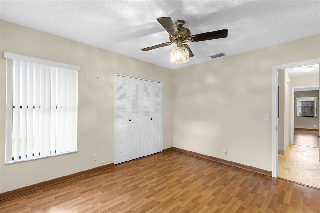 10971 Lake Front Place, Unit 10971 Boca Raton, FL 33498 - Photo 18 of 33 an empty room with wooden floor fan and windows