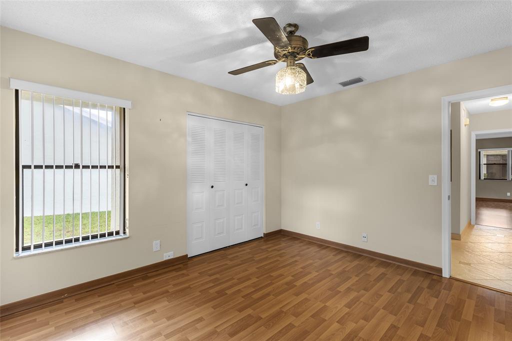 10971 Lake Front Place, Unit 10971 Boca Raton, FL 33498 - Photo 19 of 33 an empty room with wooden floor fan and windows