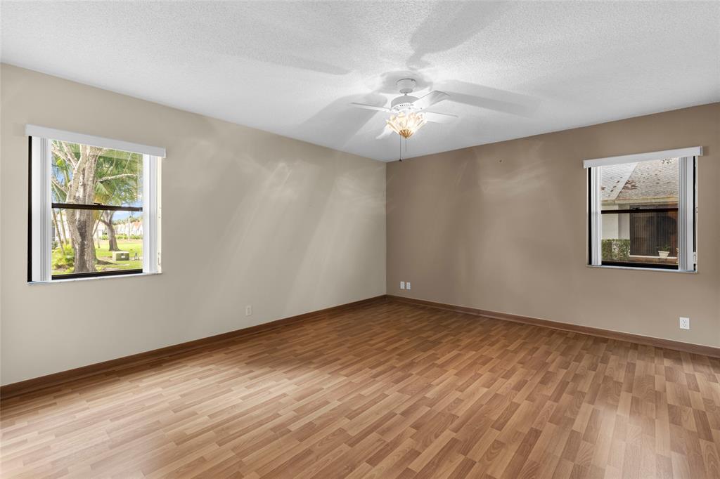 10971 Lake Front Place, Unit 10971 Boca Raton, FL 33498 - Photo 20 of 33 a view of an empty room with chandelier fan and wooden floor