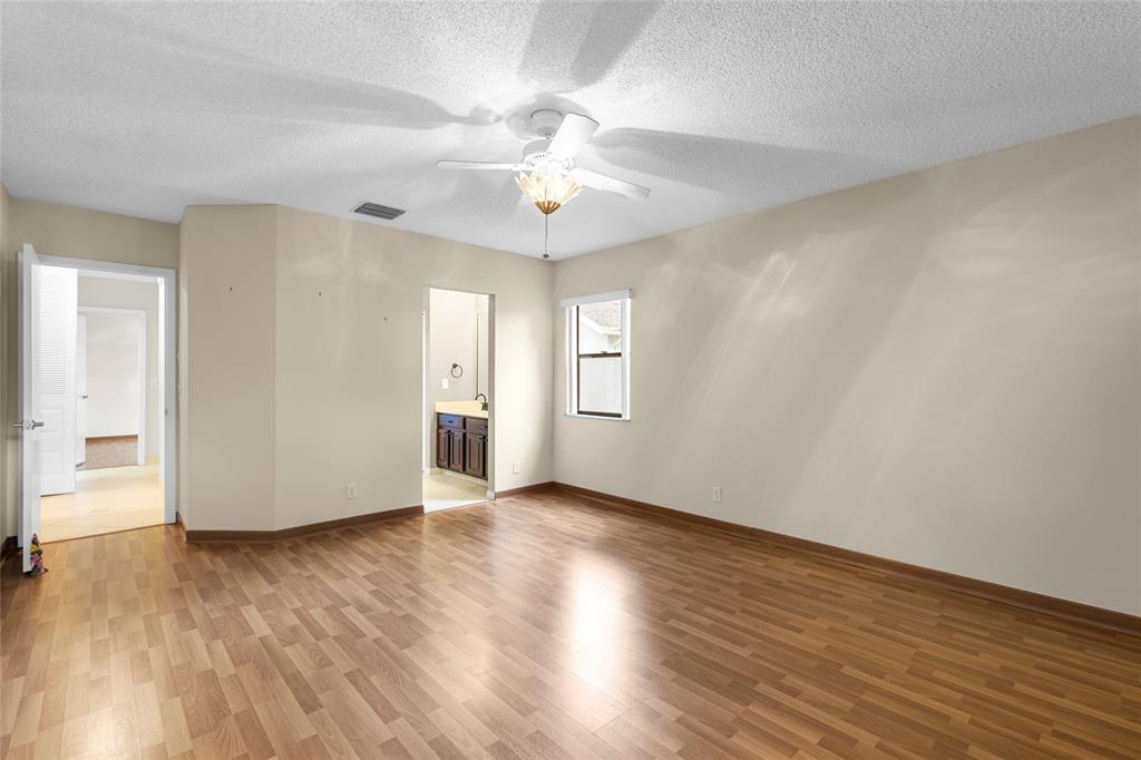 10971 Lake Front Place, Unit 10971 Boca Raton, FL 33498 - Photo 21 of 33 a view of an empty room with wooden floor and a ceiling fan