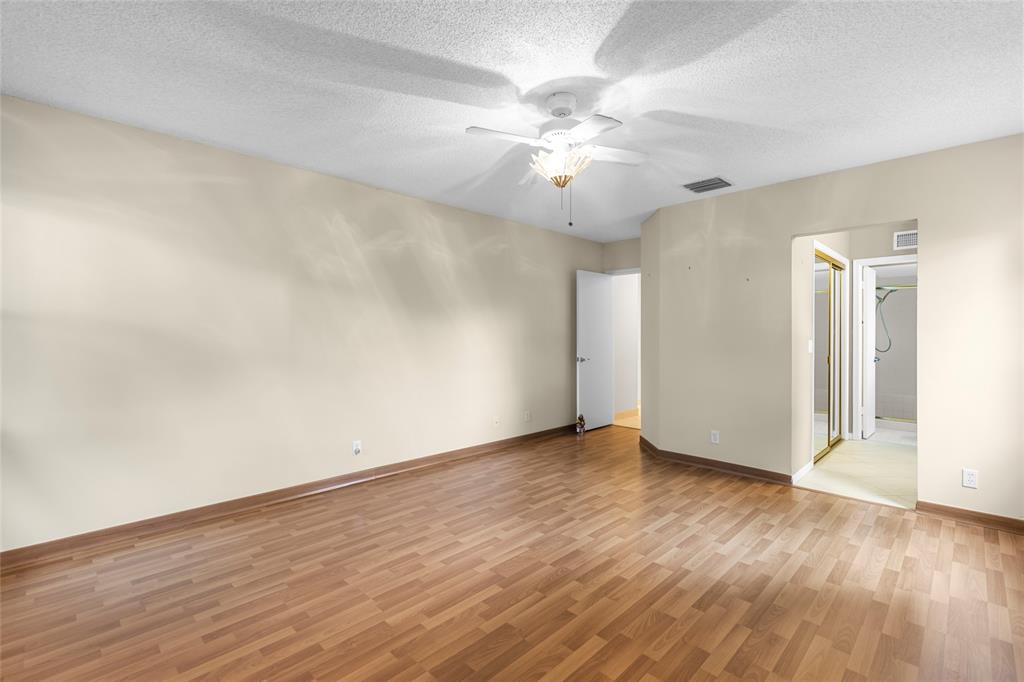 10971 Lake Front Place, Unit 10971 Boca Raton, FL 33498 - Photo 22 of 33 an empty room with wooden floor and fan