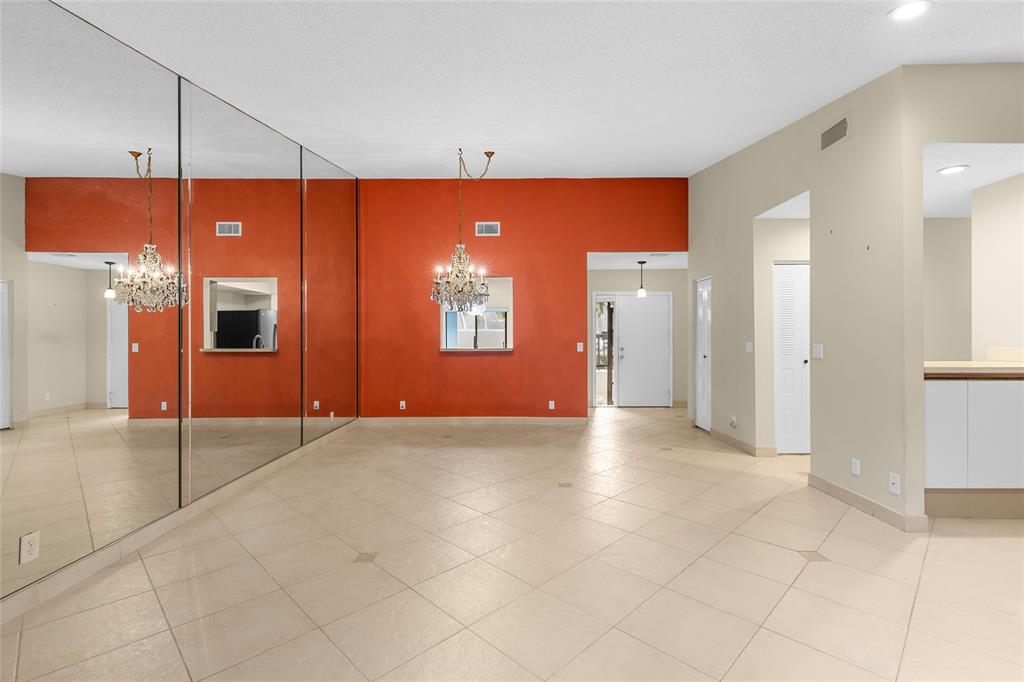 10971 Lake Front Place, Unit 10971 Boca Raton, FL 33498 - Photo 10 of 33 a view of an empty room with a fireplace and a chandelier