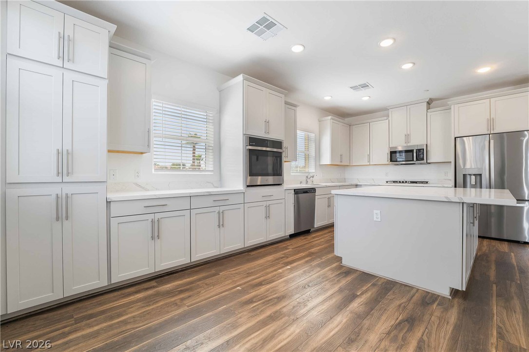 2555 Hampton Road, Unit 10202 Henderson, NV 89052 - Photo 16 of 35 Gleaming hardwood floors anchor this light-filled culinary space featuring custom cabinetry and stone countertops.