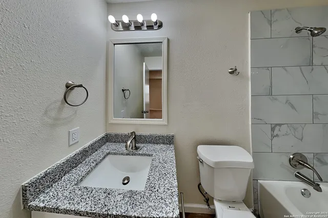 a bathroom with a sink a toilet and a mirror