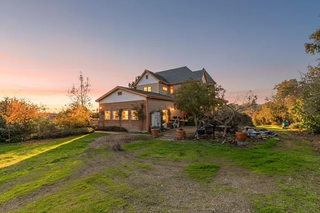 a dining room with furniture a chandelier and large windows