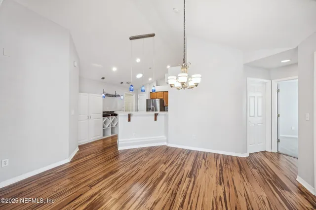 a kitchen with stainless steel appliances white cabinets and wooden floor