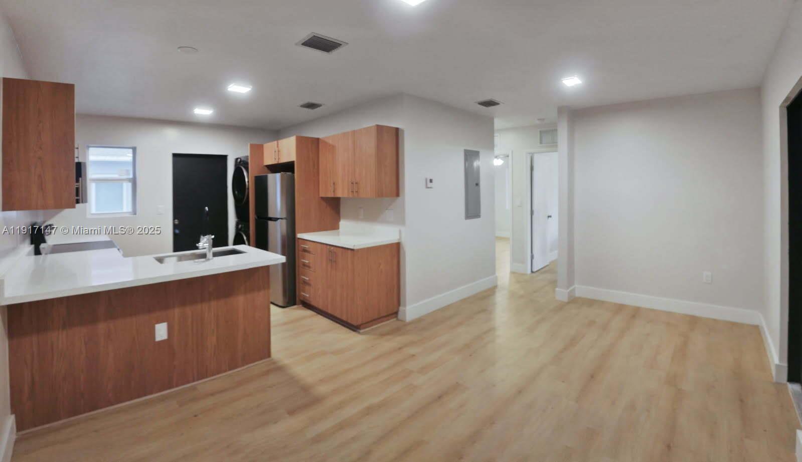 a view of kitchen with stainless steel appliances granite countertop a sink and a refrigerator