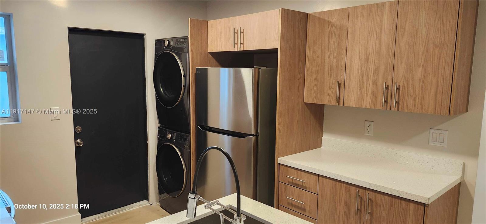 4557 Northwest 14th Avenue, Unit 4557 Miami, FL 33142 - Photo 3 of 13 a kitchen with metallic refrigerator freezer and a dishwasher