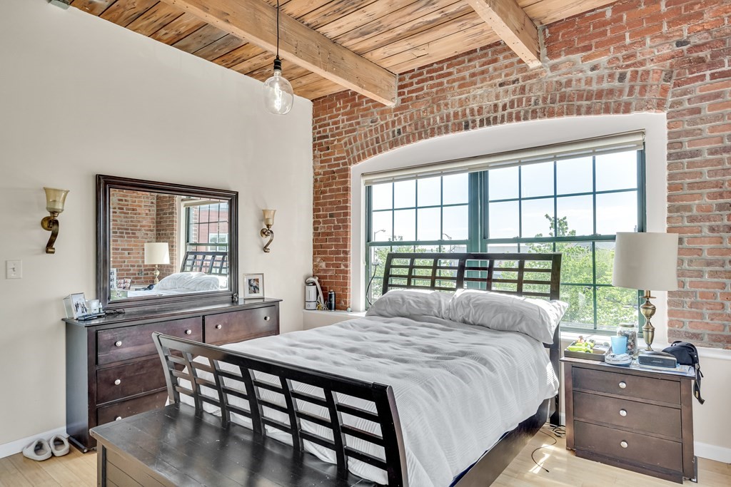 210 Broadway, Unit 301 Everett, MA 02149 - Photo 12 of 16 a bedroom with a bed and a table