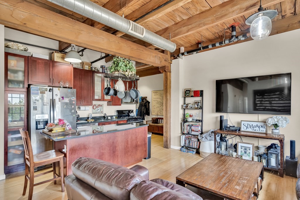 210 Broadway, Unit 301 Everett, MA 02149 - Photo 6 of 16 a living room with furniture a flat screen tv and a table