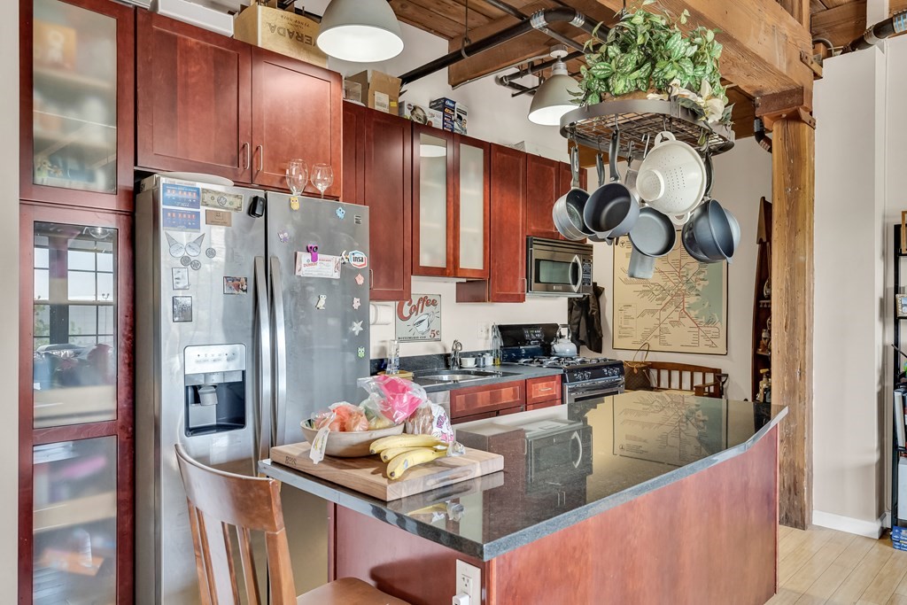 210 Broadway, Unit 301 Everett, MA 02149 - Photo 7 of 16 a kitchen with stainless steel appliances granite countertop a sink refrigerator and cabinets