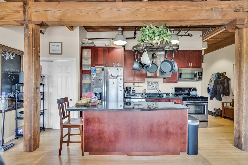 210 Broadway, Unit 301 Everett, MA 02149 - Photo 8 of 16 a kitchen with stainless steel appliances granite countertop a table and chairs in it