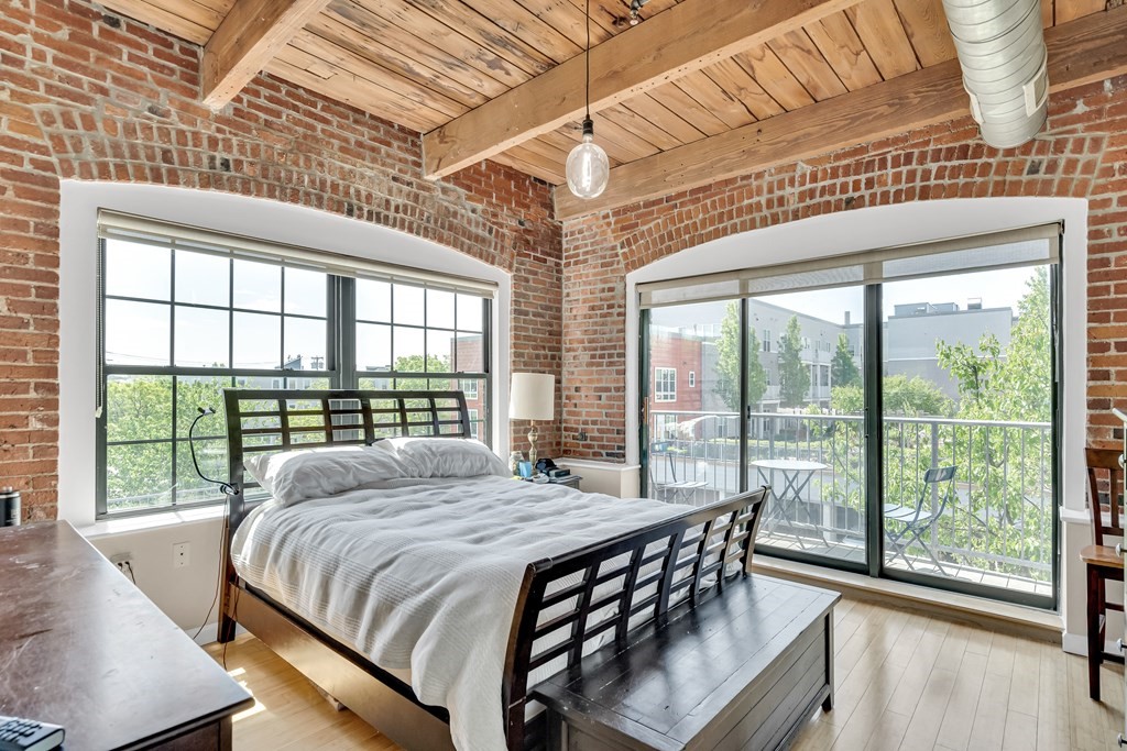 210 Broadway, Unit 301 Everett, MA 02149 - Photo 9 of 16 a bedroom with a bed and a large window