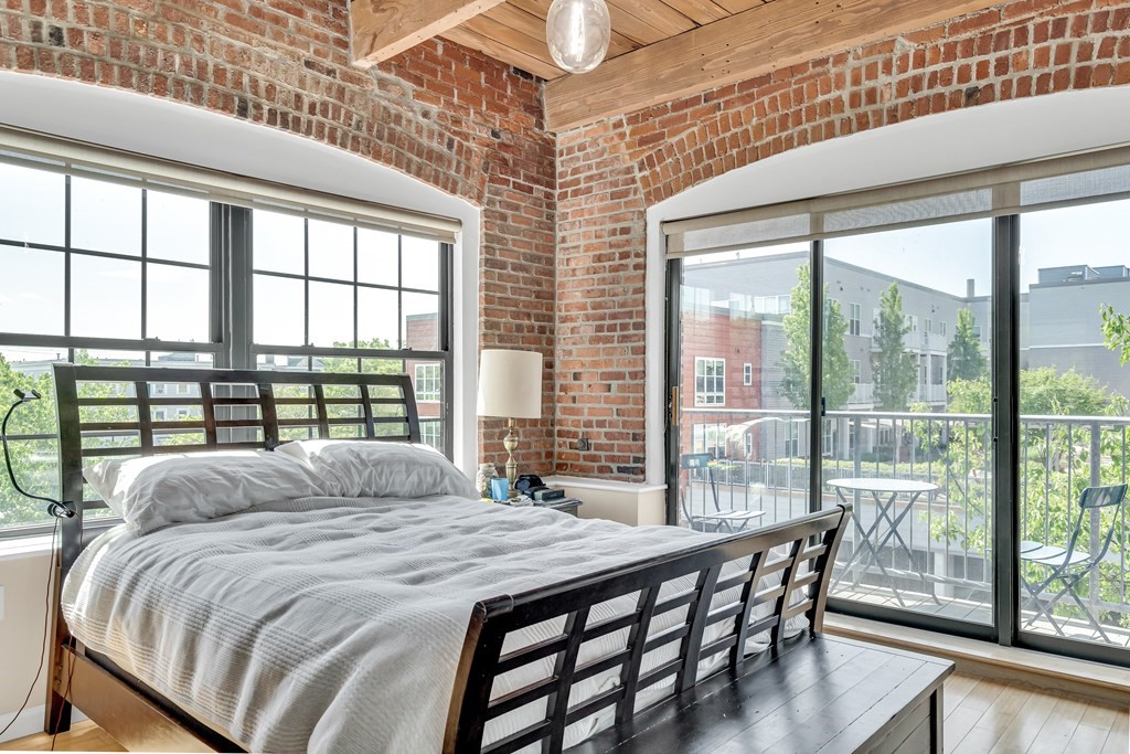 210 Broadway, Unit 301 Everett, MA 02149 - Photo 10 of 16 a bedroom with a bed and a large window