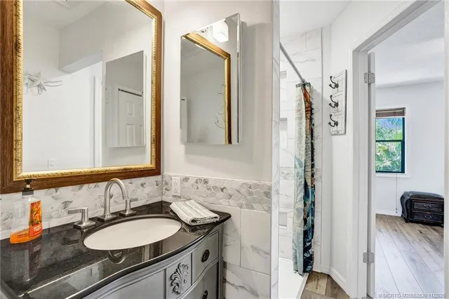 a bathroom with a granite countertop sink and a mirror