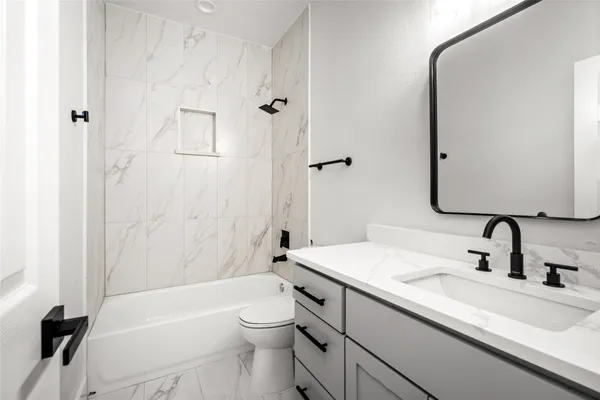 a bathroom with a sink a toilet and a mirror