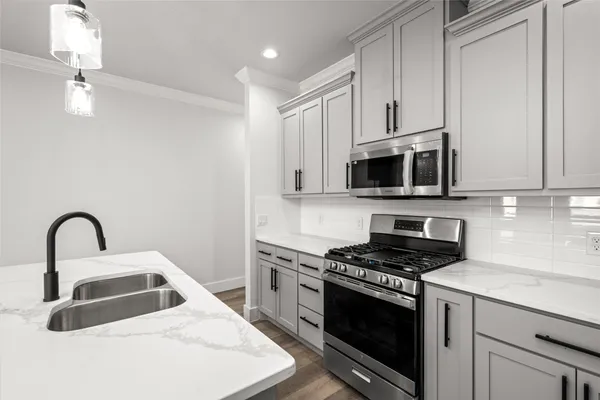 a kitchen with granite countertop a sink stainless steel appliances and cabinets