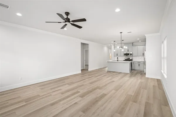 a view of kitchen with sink microwave and wooden floor