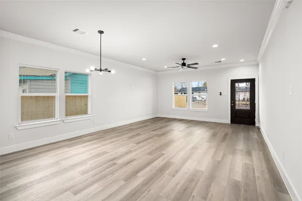 a view of an empty room with a window and wooden floor