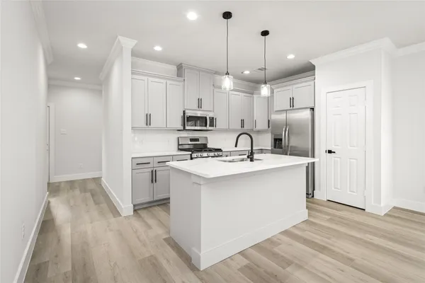 a kitchen with kitchen island a sink stainless steel appliances and cabinets