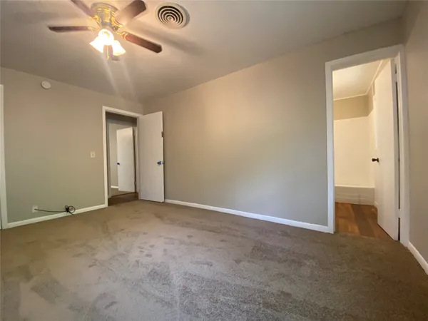 an empty room with a ceiling fan and a window