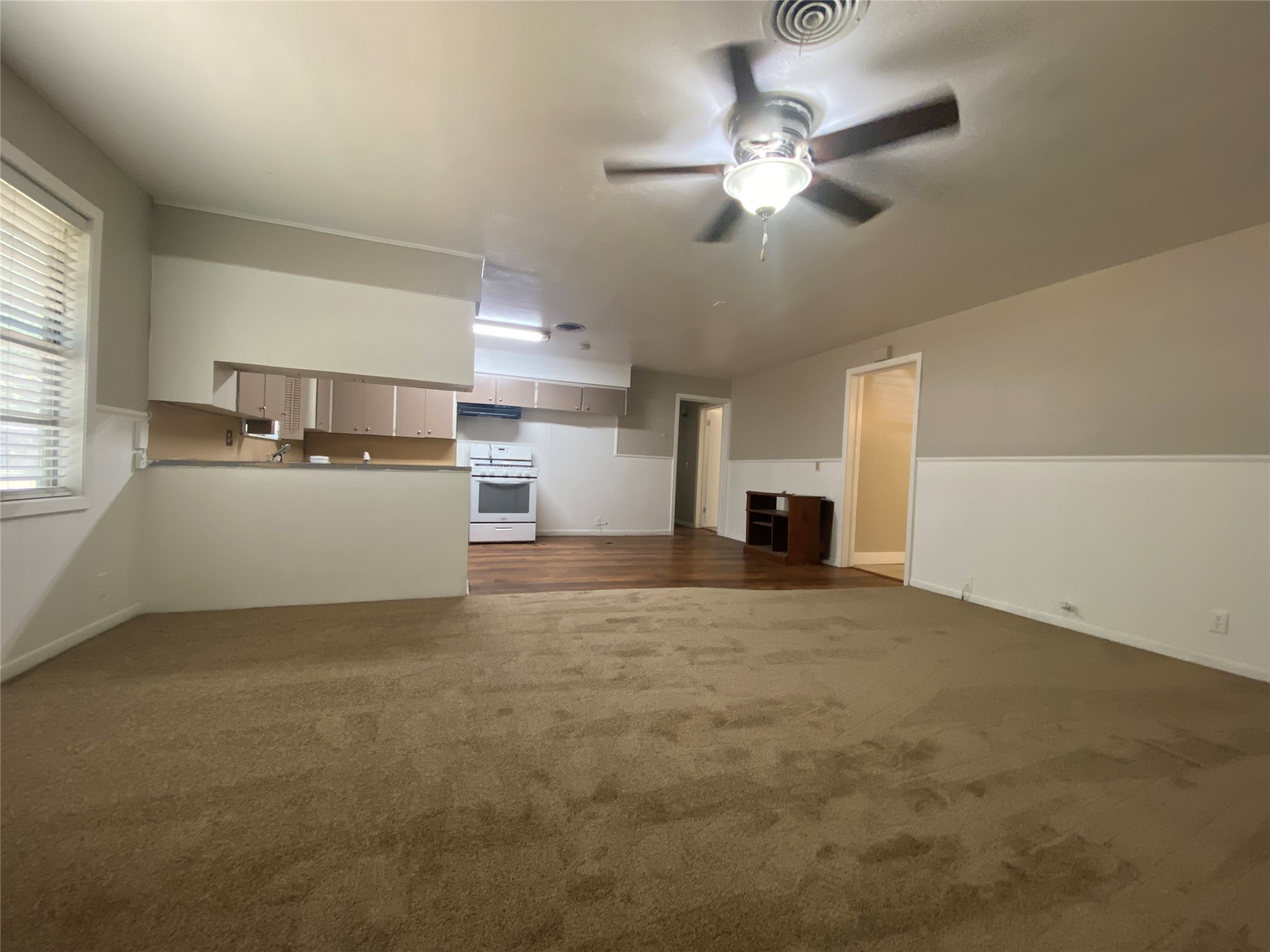802 Mable Street El Campo, TX 77437 - Photo 5 of 15 a view of a livingroom with a fireplace a ceiling fan and windows