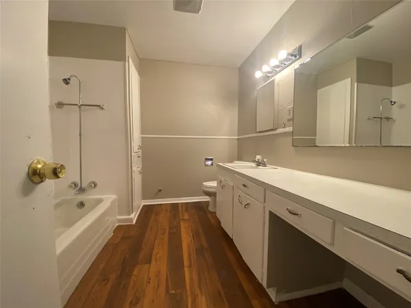 a bathroom with a tub a sink and mirror