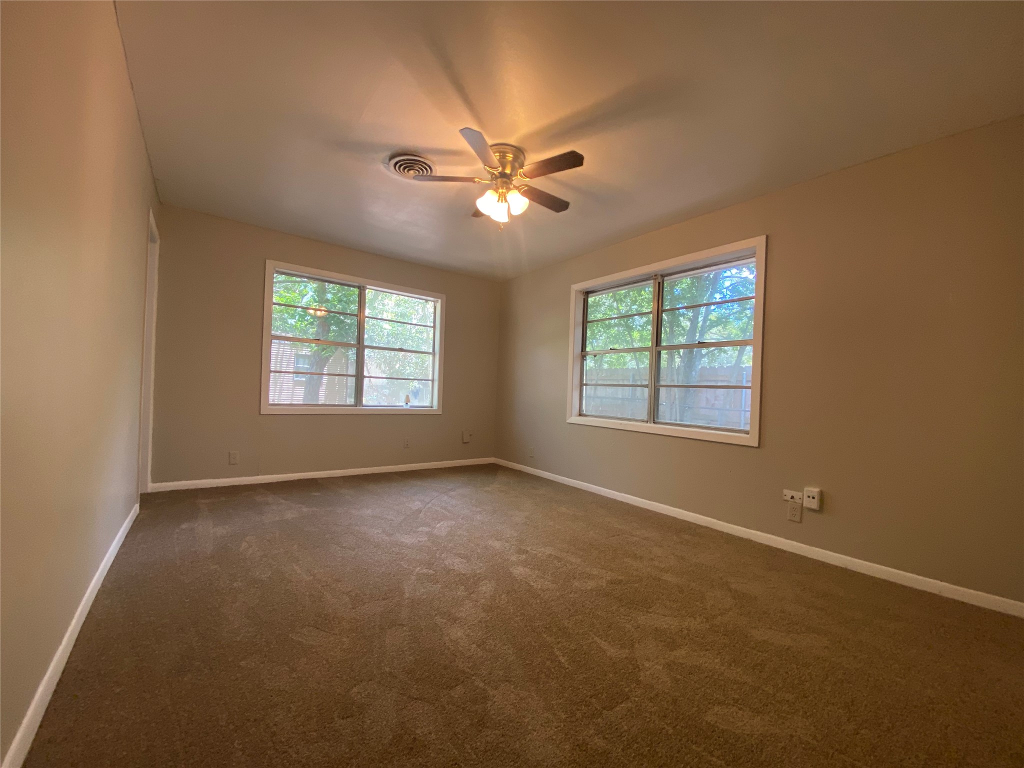 802 Mable Street El Campo, TX 77437 - Photo 10 of 15 a view of an empty room with window and chandelier fan