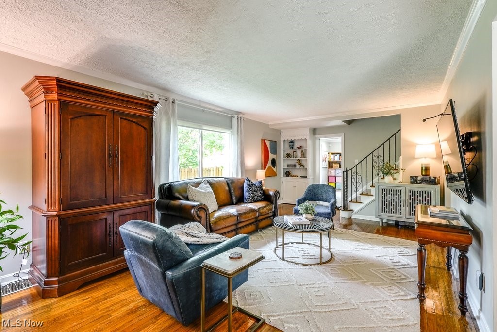 2340 Canterbury Road University Heights, OH 44118 - Photo 10 of 29 Living room featuring a textured ceiling, stairway, and light wood-style floors