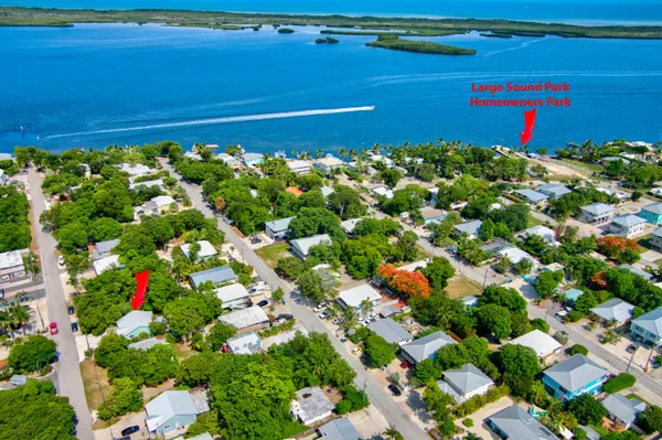 a kitchen with stainless steel appliances a stove top oven a sink and white cabinets with wooden floor