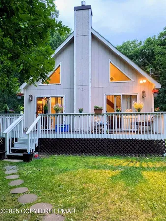 a view of a house with wooden deck and a yard