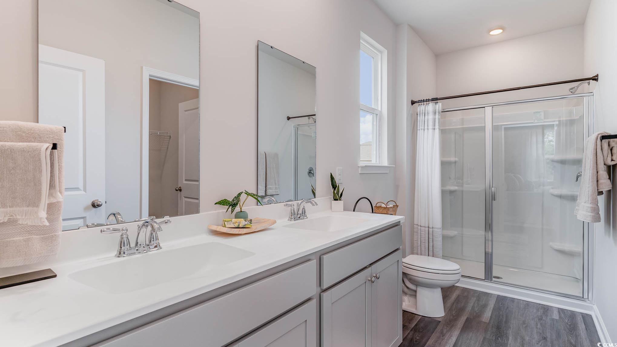 113 Homestead Way Myrtle Beach, SC 29588 - Photo 14 of 20 Bathroom with a shower stall, double vanity, and dark wood-style flooring