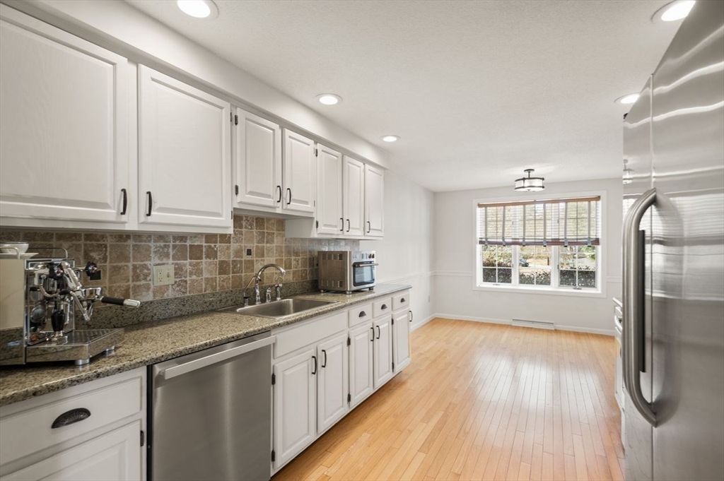 8 Bellingham Court, Unit 92 Middleton, MA 01949 - Photo 12 of 35 a kitchen with stainless steel appliances granite countertop a sink and cabinets