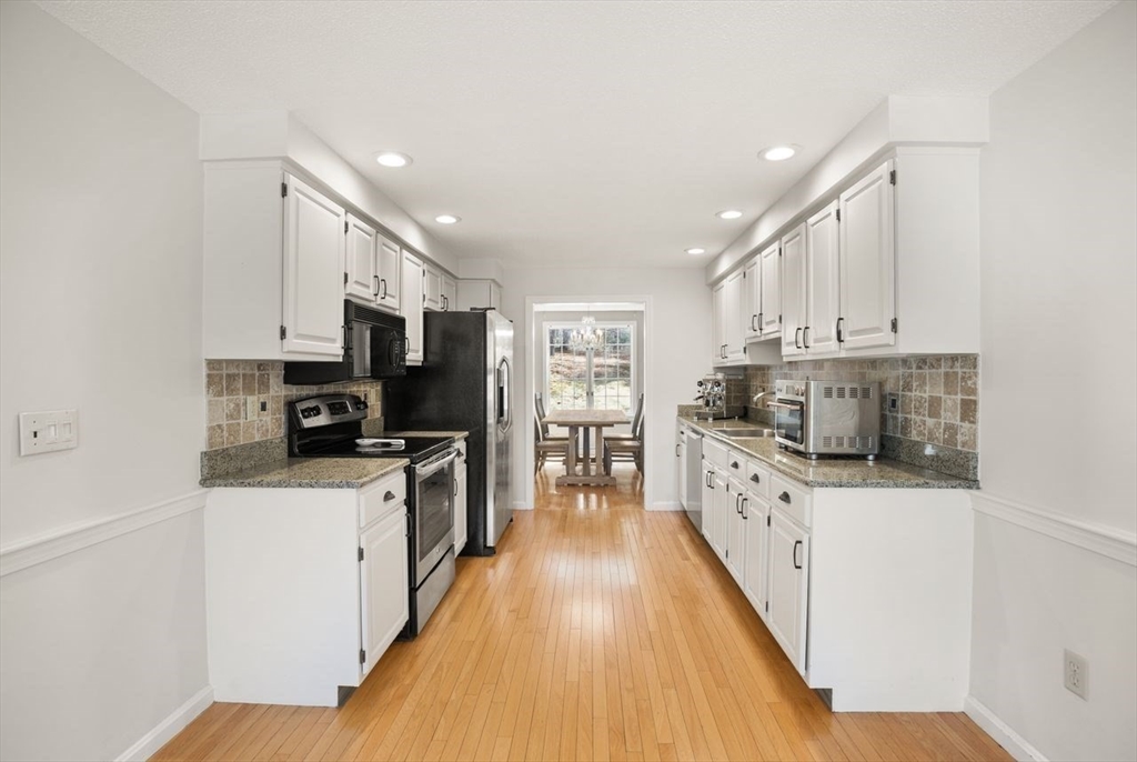 8 Bellingham Court, Unit 92 Middleton, MA 01949 - Photo 13 of 35 a large kitchen with stainless steel appliances and a stove top oven