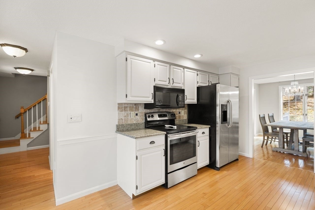 8 Bellingham Court, Unit 92 Middleton, MA 01949 - Photo 14 of 35 a kitchen with stainless steel appliances a stove top oven a refrigerator a sink and dishwasher with wooden floor