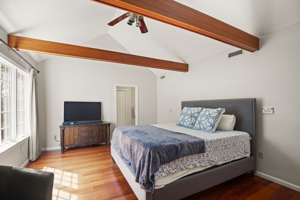 8 Bellingham Court, Unit 92 Middleton, MA 01949 - Photo 18 of 35 a living room with a bed furniture and a flat screen tv