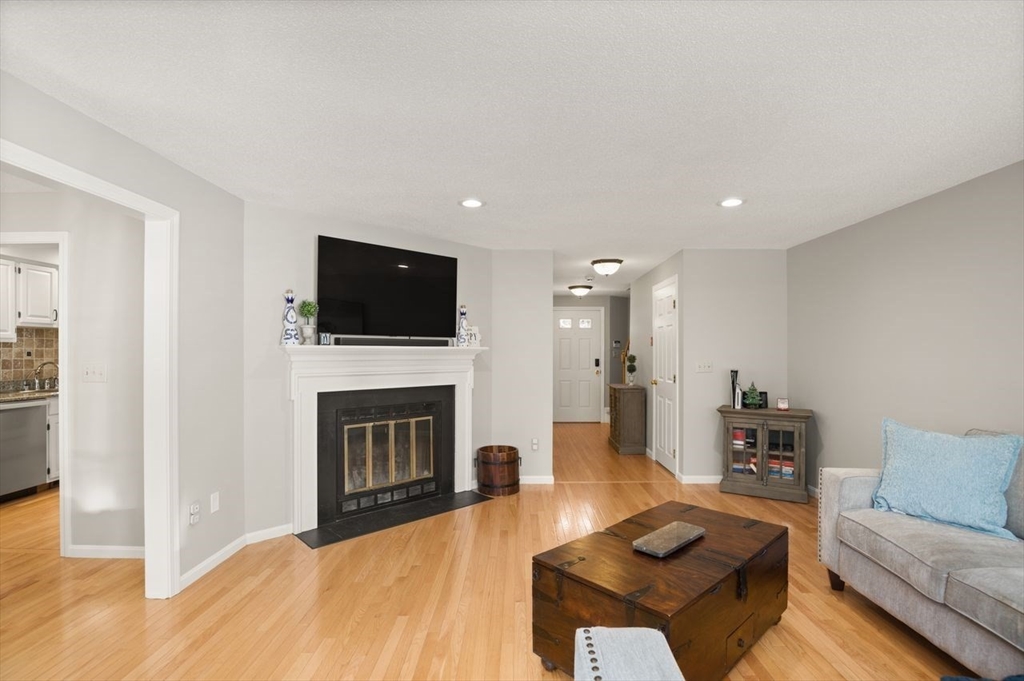 8 Bellingham Court, Unit 92 Middleton, MA 01949 - Photo 7 of 35 a living room with furniture a fireplace and a flat screen tv