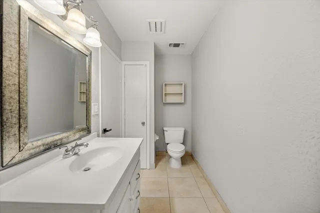 a bathroom with a sink and mirror with toilet