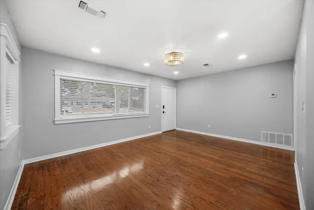 an empty room with wooden floor and window