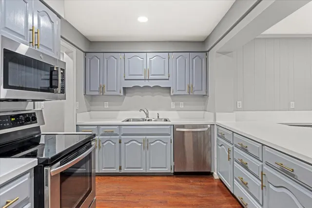 a kitchen with a stove sink and cabinets