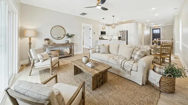 a living room with furniture a rug kitchen view and a chandelier