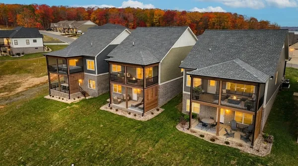 an aerial view of residential houses with yard and mountain view in back