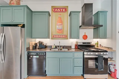 a kitchen with stainless steel appliances a stove a refrigerator and a sink