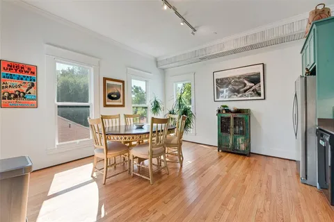 a view of a dining room with furniture a chandelier and wooden floor