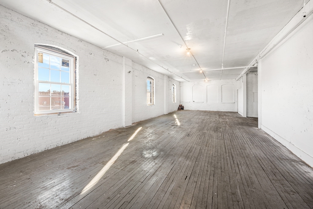 64 Green Street Worcester, MA 01604 - Photo 4 of 11 an empty room with wooden floor and windows
