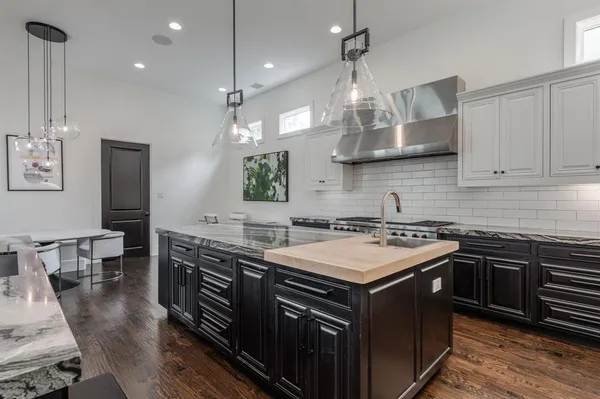 a kitchen with stainless steel appliances granite countertop a stove a sink dishwasher and a wooden cabinets with wooden floor