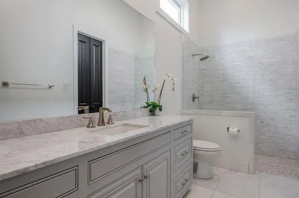 a bathroom with a granite countertop sink a toilet and a mirror