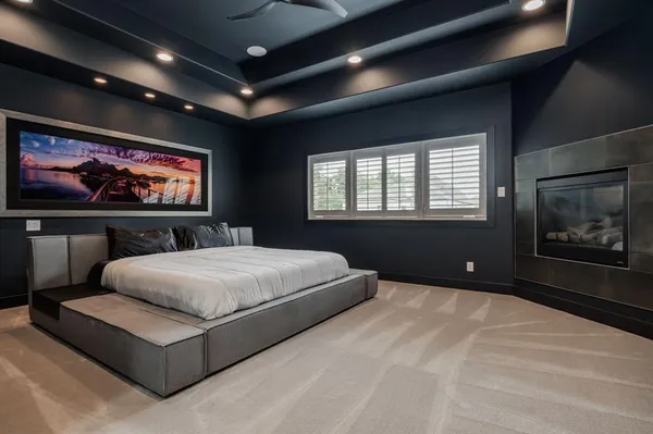 a spacious bedroom with a large bed and a chandelier