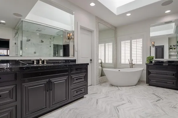 a large bathroom with a large tub and double vanity sink