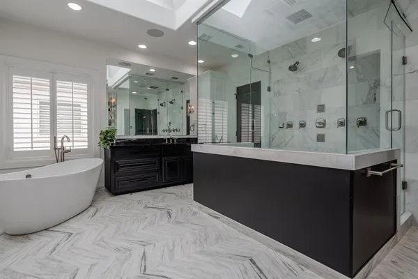 a spacious bathroom with a bathtub sink and mirror